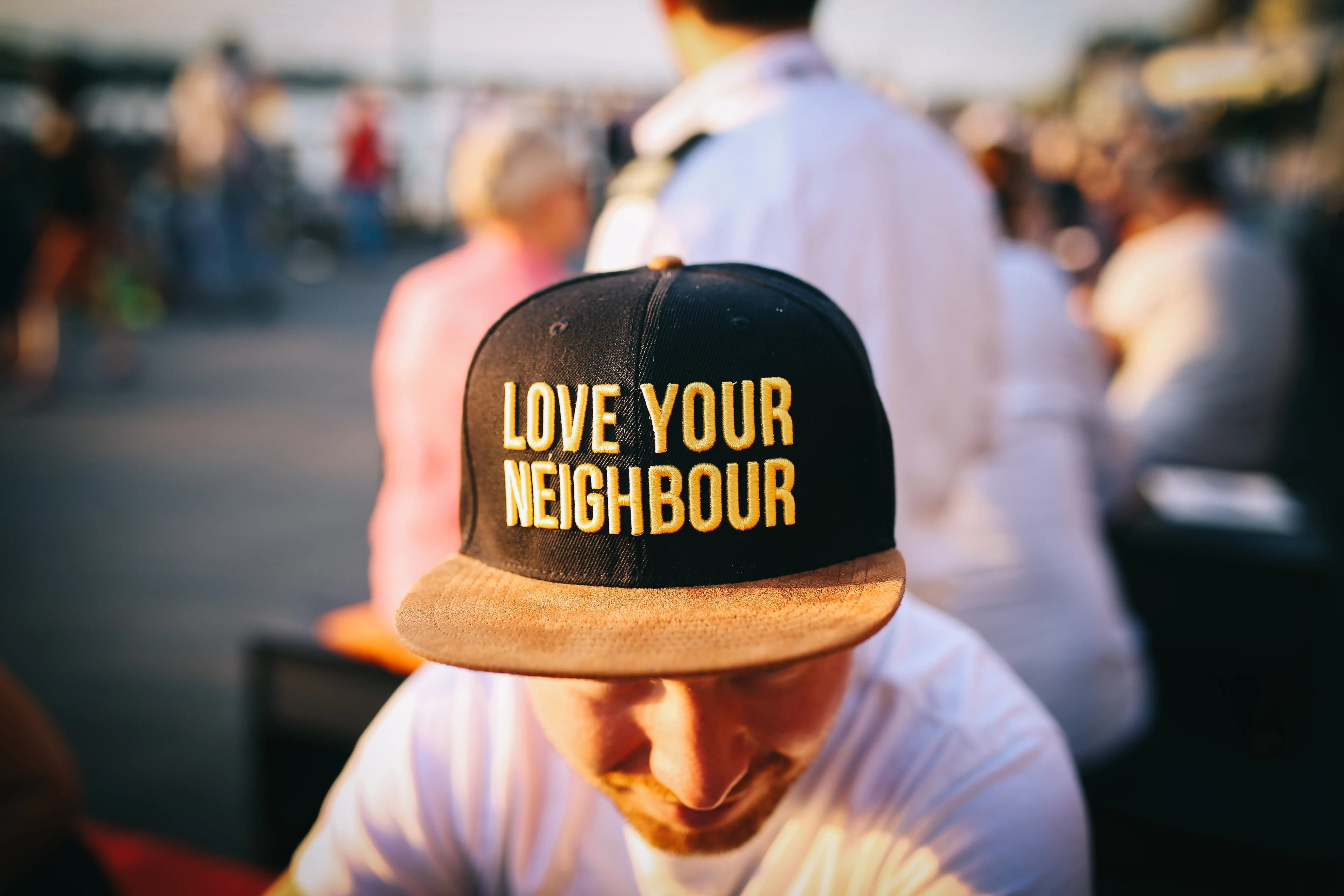 A man with a hat that says "Love Your Neighbor".